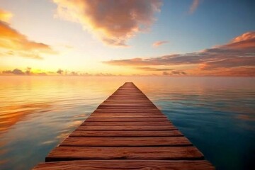 Obraz premium A rustic wooden pier extends over a calm lake at sunrise, reflecting soft orange and pink hues across the misty water, creating a serene atmosphere with open space