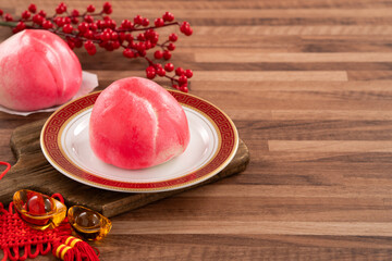 Pink Chinese peach birthday bun food shoutao on wooden table background.