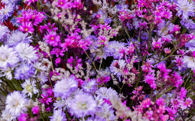 Obraz premium Selective focus, bunches of beautiful flowers bouquet in the market, bright mixed colorful flowers bouquet in vintage paper in florist shop