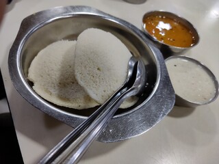 Closeup of an Indian breakfast known as idly, which is cooked in steam and is served with chutney and curry. Idly is a zero-cholesterol, healthy breakfast.