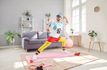 Funny man doing stretching at home, capturing a selfie for online social media using mobile phone....
