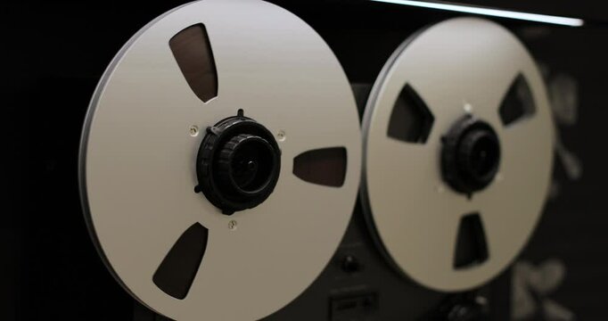 Reel to reel tape recorder playing. Rotating vintage music player close up. Retro tape. Old school concept.