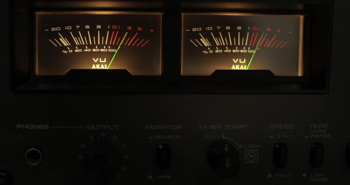 Analog VU meters on classic hi-fi reel-to-reel tape recorder. Retro sound level meter decibel meter in studio, vintage audio equipment.