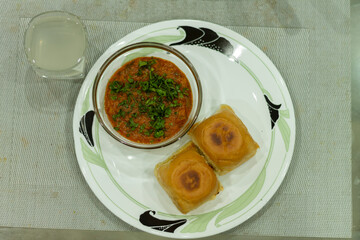 Pav Bhaji is a fast food dish from India, Thick and spicy vegetable curry, fried and served with a soft bread Bun Pav and butter. selective focus