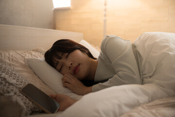 Woman who fell asleep while looking at her phone Yellow indirect lighting