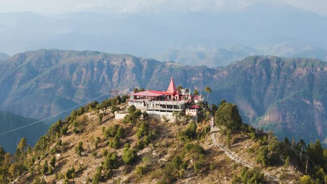 Aerial drone shot of a hindu temple on top of the mountain in uttarakhand