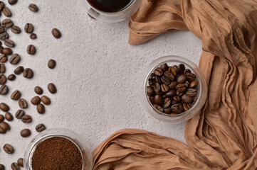 Top view fresh aromatic grain, ground and coffee drink in a small glasses, white background, brown cloth