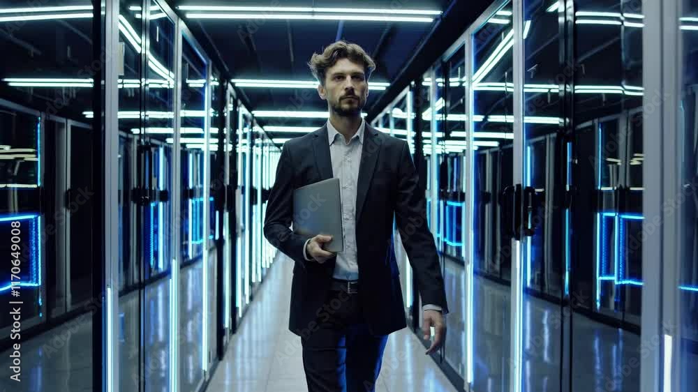 Poster professional walking through a modern data center highlighting technology and infrastructure