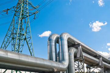 pipeline and power line against blue sky with clouds