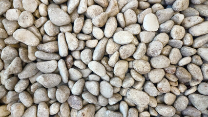 Stone wall texture with natural grey rocks and smooth pebbles forming an abstract outdoor pattern