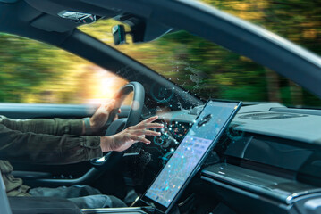 A person in a modern car interacts with a high-tech touchscreen interface displaying digital data...