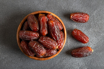 Large dates fruit in a wooden bowl, top view