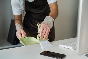 Professional Cleaning Service with Dustpan and Brush on Desk in Modern Office Environment