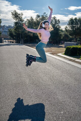 Happy sportswoman jumping with inline skates and headphones in a park