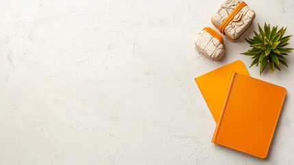 Bright Orange Notebook and Accessories on a Neutral Background with a Touch of Greenery for Creative Inspiration