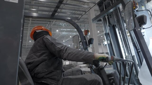 A Professional Worker Responsible for Operating a Forklift in an Industrial Warehouse Setting. Clip