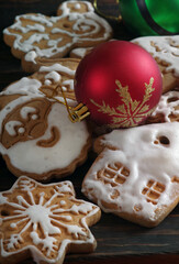 Christmas gingerbread cookies in white icing and red Christmas ball on the table. holiday cookies and ball. close up
