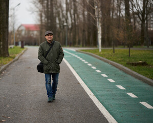 Fototapeta premium Mature man in winter coat and cap in the park
