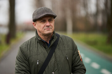 Mature man in winter coat and cap in the park