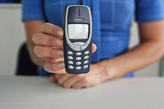 Minsk, Belarus, December 20, 2024 Businesswoman holding vintage phone nokia 3310 in hand concept