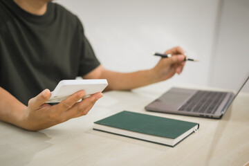 A focused man works diligently in his office, reviewing numerous accounting documents on his desk....