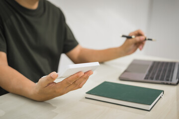 A focused man works diligently in his office, reviewing numerous accounting documents on his desk....