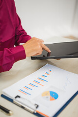 A focused man works diligently in his office, reviewing numerous accounting documents on his desk. His goal is to ensure accuracy and precision, avoiding errors in critical financial data.