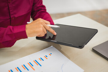 A focused man works diligently in his office, reviewing numerous accounting documents on his desk....