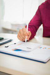 A focused man works diligently in his office, reviewing numerous accounting documents on his desk. His goal is to ensure accuracy and precision, avoiding errors in critical financial data.