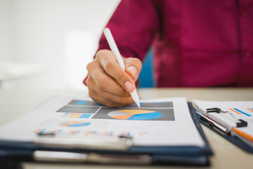 A focused man works diligently in his office, reviewing numerous accounting documents on his desk....