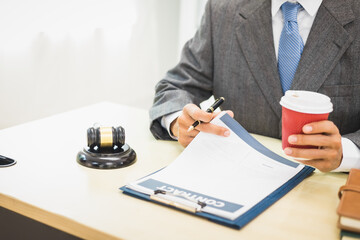 Male lawyer diligently examines documents placed on his desk, demonstrating his professionalism and dedication to finding legal truth, analyzing ideas, and pursuing justice with relentless focus.