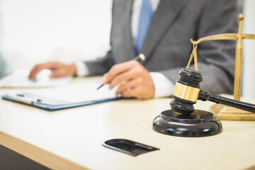 Male lawyer diligently examines documents placed on his desk, demonstrating his professionalism and dedication to finding legal truth, analyzing ideas, and pursuing justice with relentless focus.