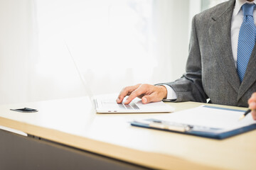 Male lawyer diligently examines documents placed on his desk, demonstrating his professionalism and dedication to finding legal truth, analyzing ideas, and pursuing justice with relentless focus.