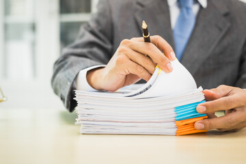 Male lawyer diligently examines documents placed on his desk, demonstrating his professionalism and...
