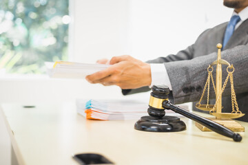 Male lawyer diligently examines documents placed on his desk, demonstrating his professionalism and dedication to finding legal truth, analyzing ideas, and pursuing justice with relentless focus.