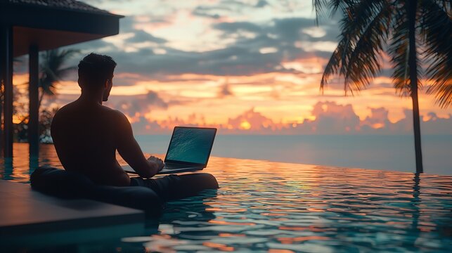 Young Man Sitting Poolside by the Swimming Pool with Laptop