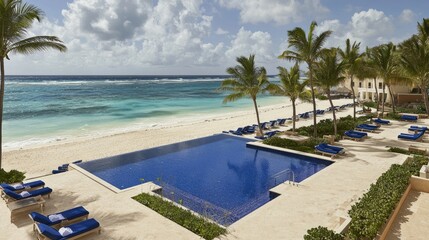 A serene beachfront view featuring a luxurious pool and palm trees by the ocean.