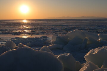 sunset on frozen shore. frozen sea, evening winter landscape, hummocks on the shore
