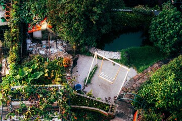 Aerial view of a lush garden with swing and pond.