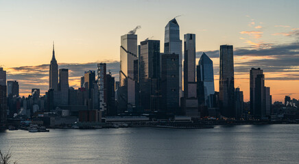 Obraz premium NYC skyscrapers in silhouette stunning morning light, city scape water reflection, background image, world famous destination