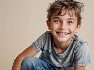 cute little boy smiling warmly and joyfully with natural brown hair, wearing a t shirt, plain background, portrait