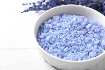 Natural sea salt and lavender flowers on white wooden table, closeup