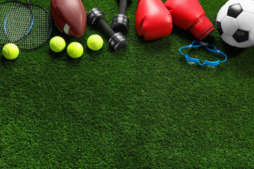 Naklejka premium Different sports equipment on artificial grass, flat lay. Space for text
