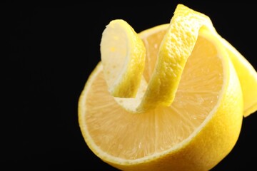 Fresh lemon peel and half of fruit on black background, closeup. Space for text