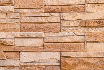 the wall is made of decorative facing stone such as Sandstone or slate. The texture of the stone. Stone facing of facades and walls.