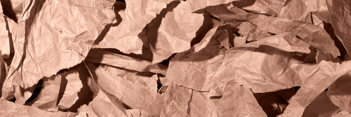 Fototapeta premium Multiple pieces of torn brown, mocha mousse crumpled, wrinkled recycle craft paper background texture, top view banner.
