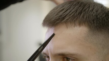 A Professional Haircut is in Progress, Showcasing the Skill of Precision Scissors Used. Clip