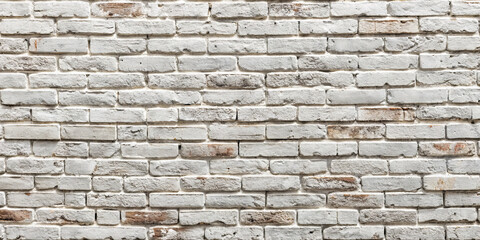 Obraz premium Close-up view of a textured white brick wall showcasing its varying tones and rustic charm. The wall adds character to the interior space, perfect for stylish decor