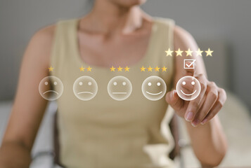 Close up of Asian customer. User presses with hand and five star icon on display screen for positive customer feedback, testimonials and confirmation. User comments and suggestions to make a review.