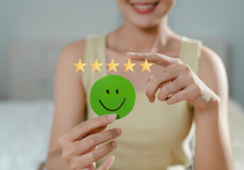 Customer's hand chooses to give 5 stars to show feedback with smiley face symbol, service...